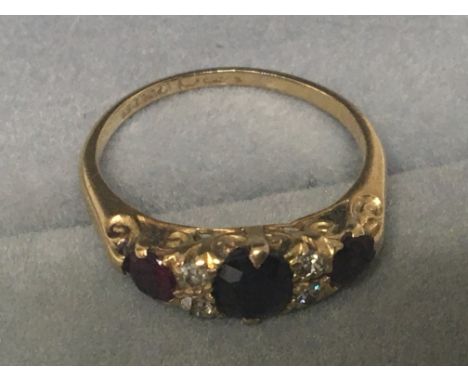 An 18carat gold ring set with ruby subdivided by small diamonds ring size M.