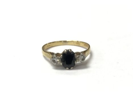 A sapphire set gold ring flanked by diamonds, measuring approximately k. Weighing 2g approximately.