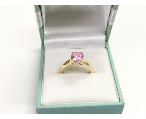 A 14k gold ring set with a pink stone, approx 2.5g and approx size K.