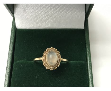 A gold ring set with a central moonstone. The approximate ring size is L.