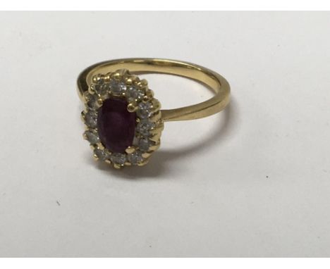 A unmarked gold ring inset with central ruby surrounded by diamonds.