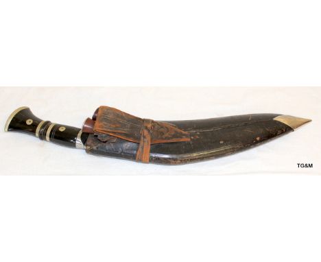 A military Kukri in its leather covered wood scabbard complete with its two sharpening knives. Marked to the blade Military S