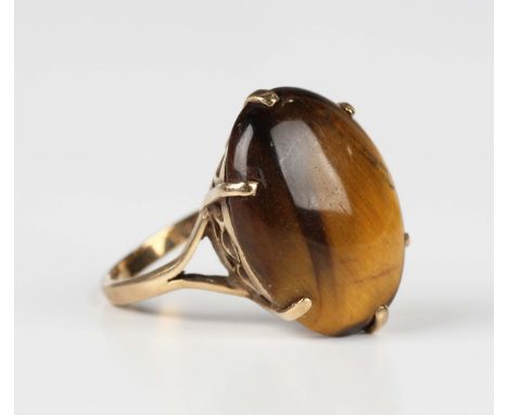 A 9ct gold ring, claw set with an oval tiger's eye, Birmingham 1971, weight 5.4g, ring size approx N, with a case.Buyer’s Pre