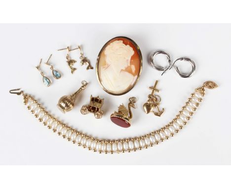 A gold charm representing faith, hope and charity, detailed '750', weight 1.7g, a 9ct gold bottle charm, a 9ct gold and corne