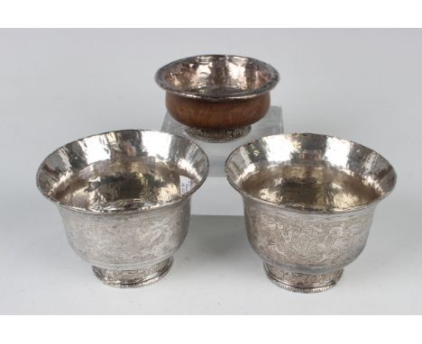 A pair of Chinese silver circular cups, each engraved with dragons chasing the flaming pearl beneath a flared rim, on a circu
