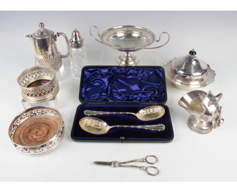 A group of plated items, including two wine coasters, a two-handled tazza, a pair of serving spoons with floral decoration an