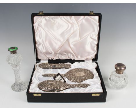 An Elizabeth II silver mounted three-piece dressing table set with bird, mask and foliate scroll decoration, comprising hand 