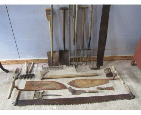 A mixed collection of weathered hand tools to include twin handled saws, further garden tools 