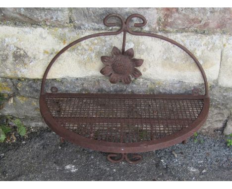 A weathered iron work wall mounted demi-lune wire meshed panelled shelf with sunflower detail, simple scrolled outline and fi