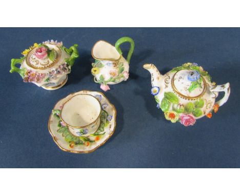 A miniature German porcelain (probably Meissen) tea service comprising teapot, sucrier and cover, milk jug, tea cup and sauce