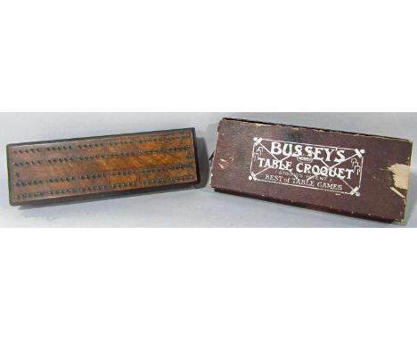 An antique walnut cribbage board with an ebonised base, complete with all of the brass pegs, together with a Bussey's table t