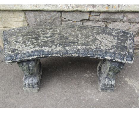 A weathered three sectional composition stone garden bench, the curved slab seat with classical repeating egg moulded surroun