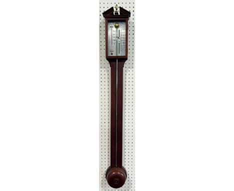 A contemporary stick barometer with silvered dial set beneath an architectural pediment 