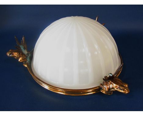 An opaque white glass ceiling light, a segmented glass bowl resting in a brass circular frame, hung from three ornamental fro