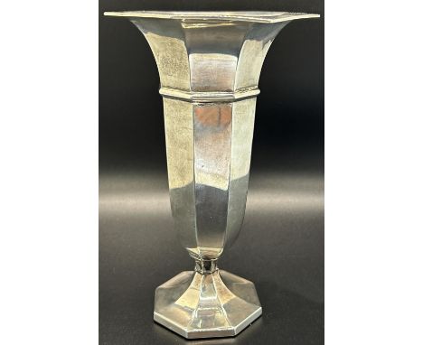 An octagonal silver posy vase, 17 cm high, a single silver candlestick and an Eastern silver metal heavily engraved tea cup 