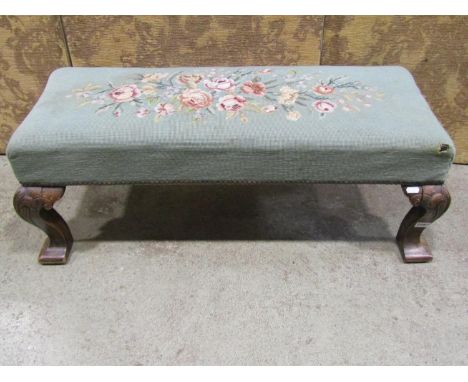 An upholstered foot stool raised on four shaped supports with tapestry top, 95 cm wide 