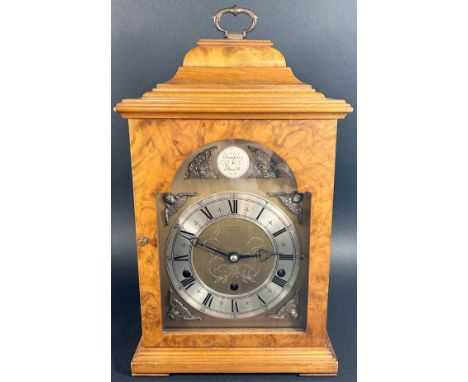 A walnut bracket clock in the Georgian style, the broken brass arched dial with cherub spandrels and silvered chapter ring en
