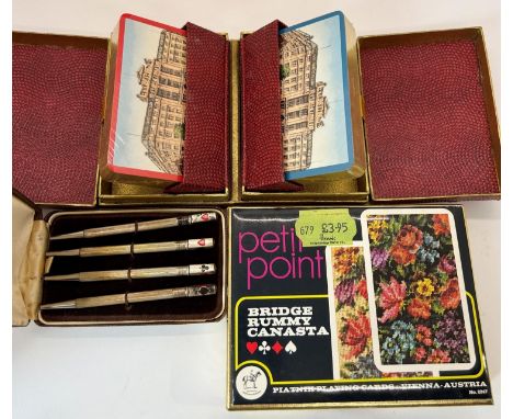 A cased set of four silver pencils each with card suit detail cased, together with several packs of vintage playing cards 