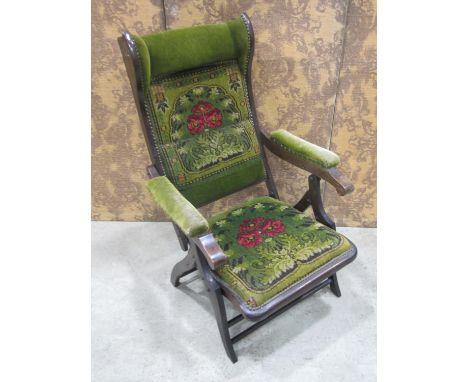 An Edwardian conservatory chair with folding frame with original carpet panelled seat back and arm panels 