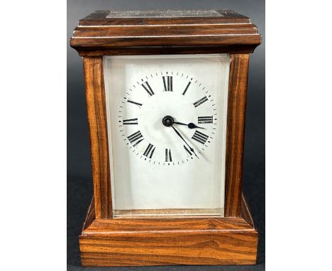A small 19th century mantle clock with eight day time piece within a polished walnut case - with key 