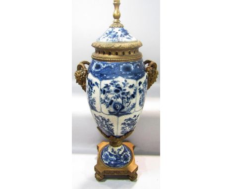 An impressive tall lamp with blue and white crackle glazed floral decoration on a gilt acanthus leaf base, with fawn head mas