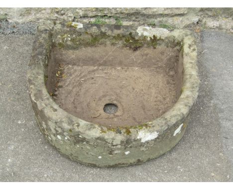 A weathered carved natural stone D shaped trough with central circular drainage hole, 57 cm wide x 52 cm deep x 20 cm high 