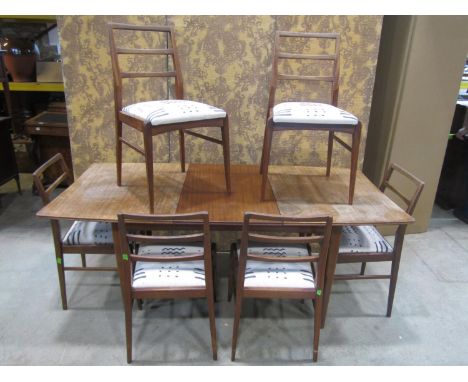 A vintage teak extending dining table with additional leaf together with 6 dining chairs with upholstered seats 