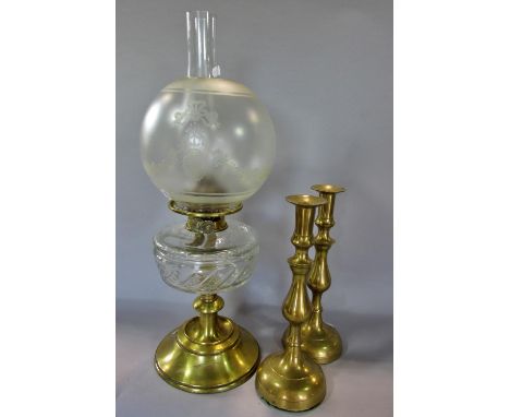 A Victorian brass oil lamp on a spread foot, with clear glass font and frosted garland decorated shade, together with a pair 