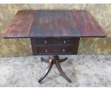 A Regency mahogany ladies work table fitted with two real and two dummy drawers raised on a turned pillar and quadruped base 