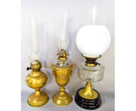 Two brass Victorian oil lamps with glass chimney's and a brass oil lamp with a spread foot, glass font and an opaque shade 
