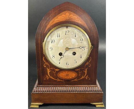 An inlaid Edwardian mahogany mantle clock, the case of lancet shape with marquetry detail with convex enamel dial and eight d