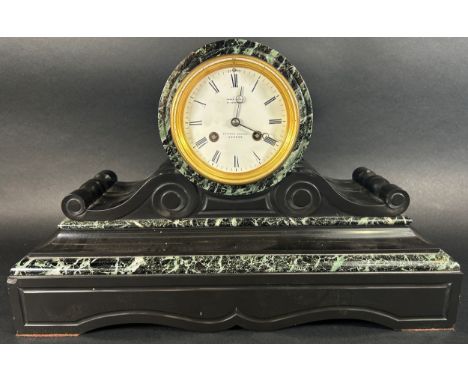 A 19th century marble and black slate mantle clock with drum head enclosing a French eight day striking movement behind an en