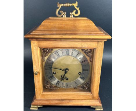 A walnut cased bracket clock in the Georgian style retailed by Dent of London, the square brass dial with cherub spandrels an