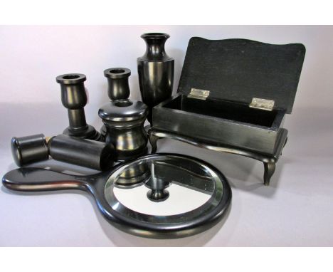 Seven vintage ebony dressing table pieces to include a hand mirror, hair pin cylinder, trinket box, a pair of candlesticks, a