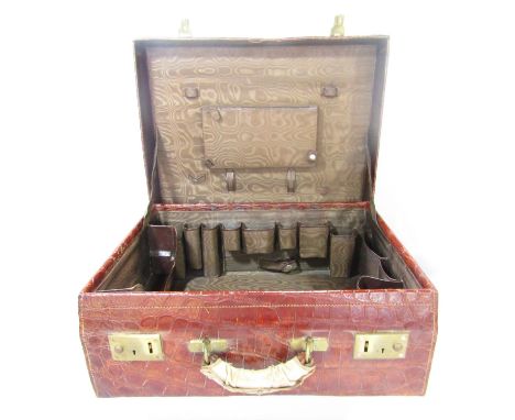 A vintage crocodile suitcase in mahogany tones, with decent stitching throughout, with sturdy handle and locks, fitted interi