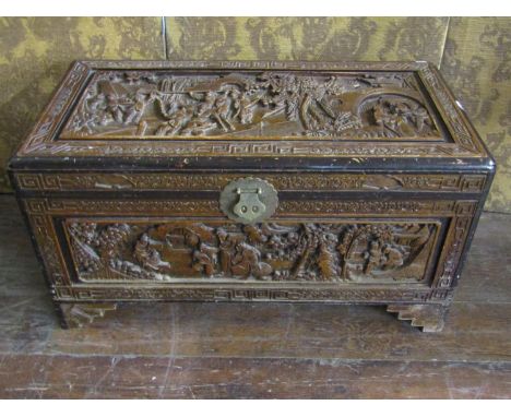 A 20th century Chinese carved camphor wood coffer, the hinged lid opening to reveal a vacant interior with removable shelf ti