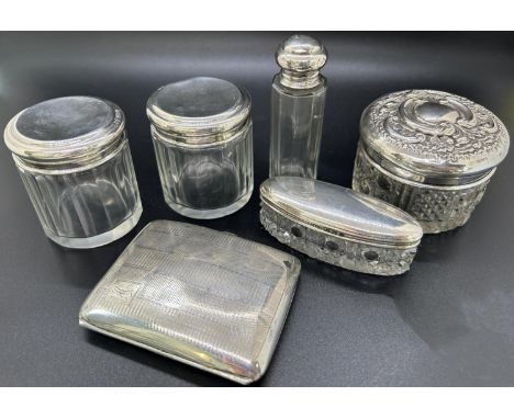 A group of glass vanity jars with silver lids decorated in various patterns, consisting of toothpick jars, cotton bud jars, e