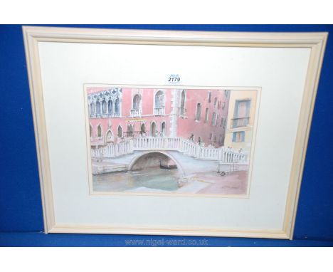 A Watercolour depicting figures crossing a bridge in Venice, signed lower right