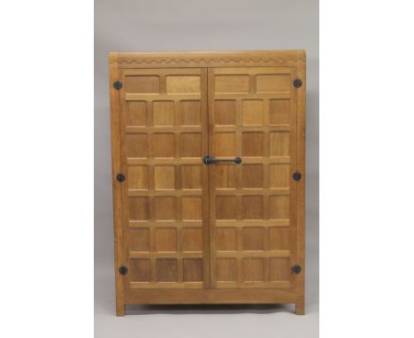 ROBERT "MOUSEMAN" THOMPSON. AN OAK TWO DOOR WARDROBE  with a pair of panelled doors, panelled ends, the interior with a hangi