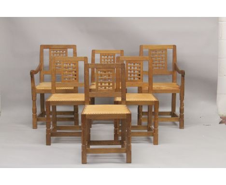 ROBERT "MOUSEMAN" THOMPSON. AN SET OF SIX OAK DINING CHAIRS, two with arms, all with lattice work back panels, close nailed t