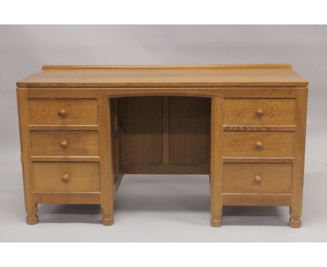 ROBERT "MOUSEMAN" THOMPSON. AN OAK KNEEHOLE DRESSING TABLE, with adzed rectangular top , panelled ends, three drawers to each