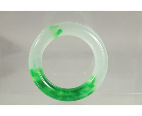 A PLAIN TWO TONE JADE BANGLE. 3.5ins diameter.