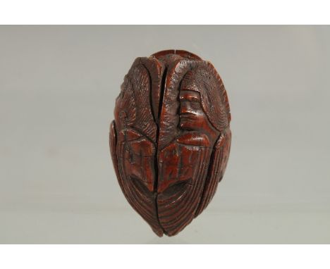 AN UNUSUAL PICTORIAL CARVED SNUFF BOX, possibly carved from a nut, depicting three figures. 2.2ins long.