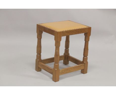 ROBERT "MOUSEMAN" THOMPSON. AN OAK STOOL with close nailed tan leather seat, on four stretchered balluster shaped legs. 1ft 3