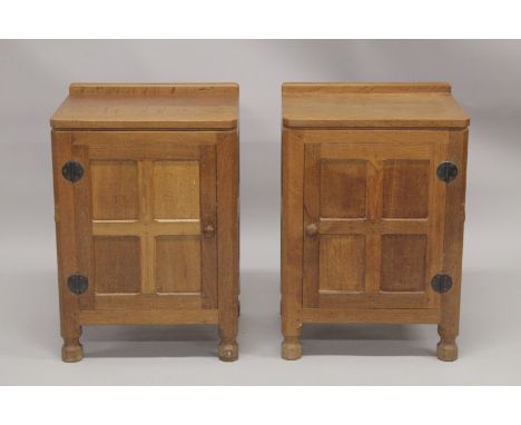 ROBERT "MOUSEMAN" THOMPSON. AN PAIR OF OAK BEDSIDE CUPBOARDS each with an adzed rectangular top, single panel door with hand 