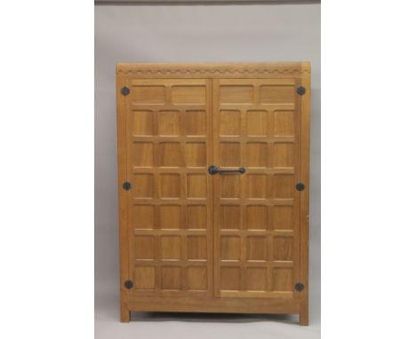 ROBERT "MOUSEMAN" THOMPSON. AN OAK TWO DOOR WARDROBE  with a pair of panelled doors, panelled ends, the interior with a hangi