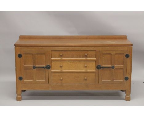 ROBERT "MOUSEMAN" THOMPSON. AN OAK LONG SIDEBOARD with adzed rectangular top, panelled ends, three central drawers flanked by