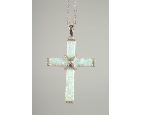 A SILVER OPAL SET CROSS on a chain.