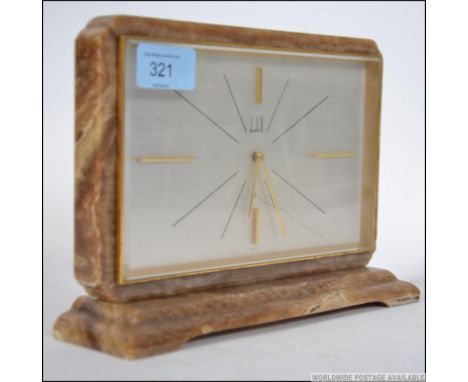 A good mid century Dunhill mantel clock within vanilla veined marble surround having silvered dial with gilded baton numerals
