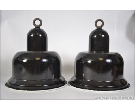 A pair of Industrial 20th century black and white enamel factory pendant shades of unusual shape having original bulb fitment